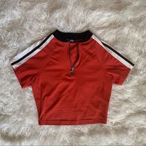 Orange striped crop top with silver zipper front.
